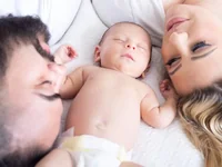 Родители с спящим младенцем