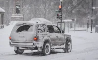 Заснеженный внедорожник у светофора