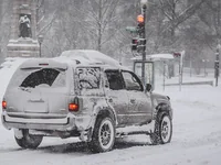 Заснеженный внедорожник у светофора