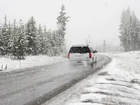 Белый внедорожник в снежном лесу