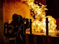 Пожарный тушит пламя